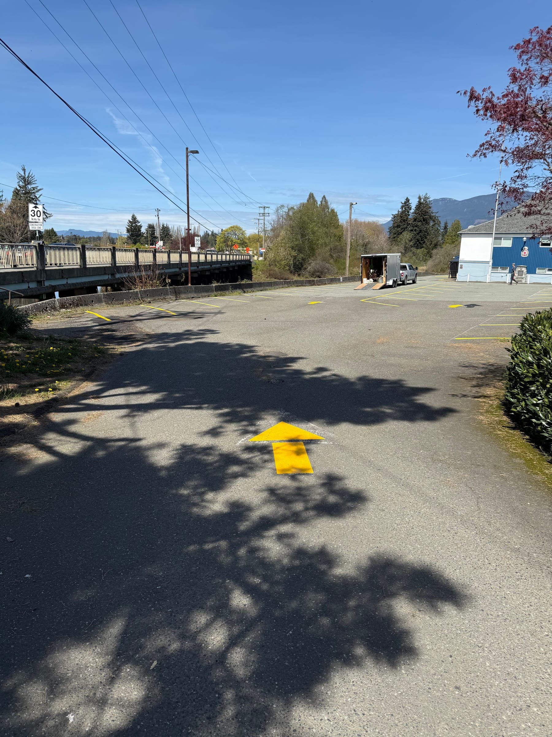 Before photo of a parking lot with faded directional arrows.