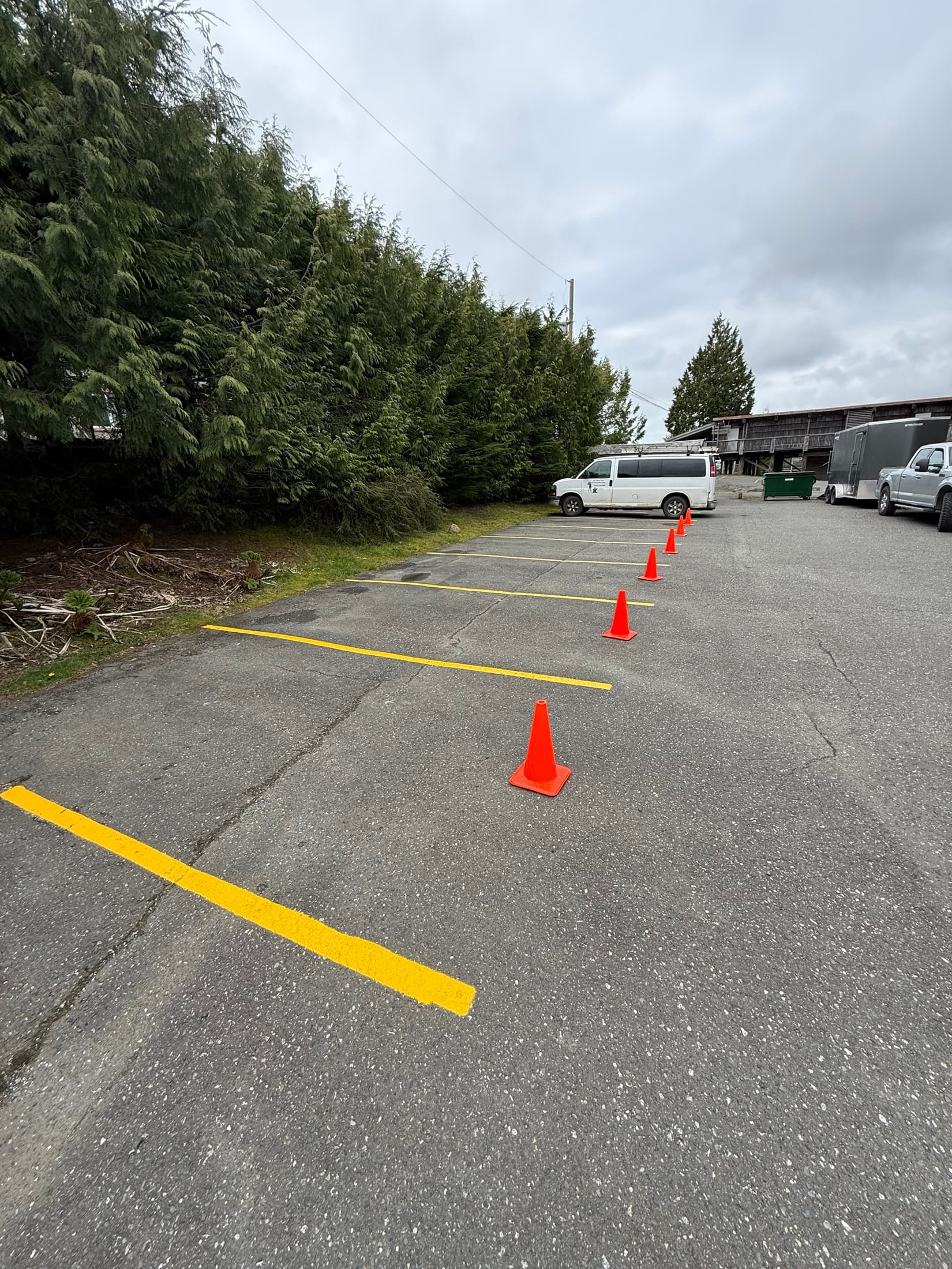 After photo of fresh yellow parking stall lines marked with safety cones.